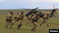 Soldați britanici debarcă dintr-un elicopter militar american în timpul exercițiilor militare NATO „Wind Spring 15”, desfășurate în România pe 21 aprilie.