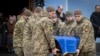Soldații poartă un sicriu al soldatului ucrainean Andrii Kuzmenko, care a fost ucis în războiul Rusia-Ucraina, în timpul unei ceremonii de rămas bun la Mănăstirea Sf. Mihail din Kiev, pe 10 ianuarie.