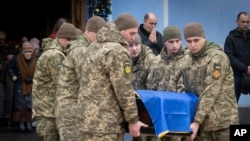 Soldații poartă un sicriu al soldatului ucrainean Andrii Kuzmenko, care a fost ucis în războiul Rusia-Ucraina, în timpul unei ceremonii de rămas bun la Mănăstirea Sf. Mihail din Kiev, pe 10 ianuarie.