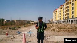 Një polic kinez qëndron pranë një kampi në Xinjiang të Kinës. Fotografi nga arkivi.
