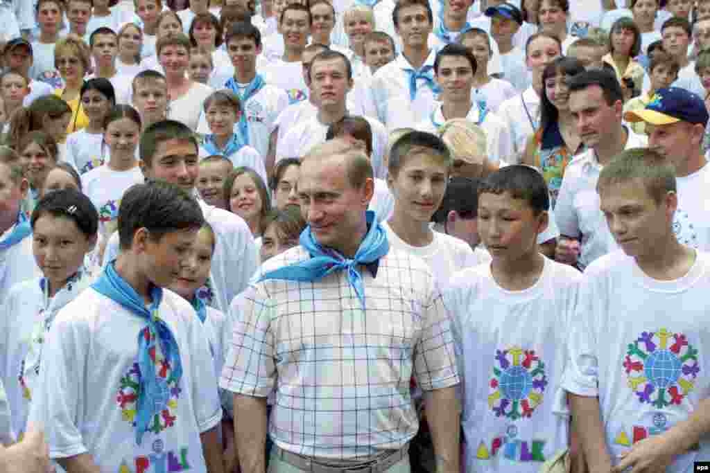 Putin viziton me kampistët &nbsp;- tani të veshur me shalle të klatra në vend të atyre të kuqe të epokës komuniste - në ARTEK në vitin 2001. Pas rënies së Bashkimit Sovjetik, emri i kampit është ndryshuar nga Pionerët e rinj, në &quot;Qendra Ndërkombëtare e Fëmijëve.&quot;