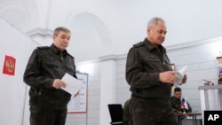 Тогашниот руски министер за одбрана Сергеј Шојгу (десно) и генералот Валери Герасимов гласаат на изборите на 15 март 2024 година.