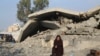 Një grua palestineze e zhvendosur nga bombardimet izraelite në Rripin e Gazës qëndron ulur pranë një shtëpie të rrënuar në Rafah, 27 dhjetor 2024.