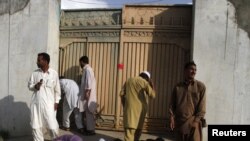 Lokalni stanovnici pokušavaju da vide preko kapije u posjed na kojem je lider Al-Kaide, Osama bin Laden ubijen u Abotabadu, u maju 2011.