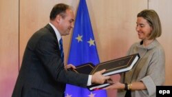 Shefja e politikës së jashtme të BE-së, Federica Mogherini (djathtas) dhe ministri i Jashtëm i Kosovës, Enver Hoxhaj, shkëmbejnë dokumentet gjatë takimit të Këshillit për Stabilizim-Asociim në Bruksel. 25 nëntor 2016.