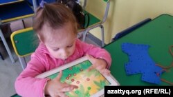 Ребенок играет в развивающие игры в центре "Капитошка". Темиртау, 26 марта 2015 года.