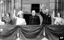 Premierul britanic Winston Churchill (centru) împreună cu familia regală - de la stânga la dreapta: Prințesa Elizabeth, Regele George VI, Regina Mary, Prințesa Margaret, în balconul Buckingham Palace, Londra, 8 mai 1945, ziua Victoriei în Europa.