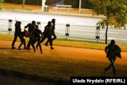 Полицията бие хора, а друг се опитва да избяга, за да се спаси от ударите.