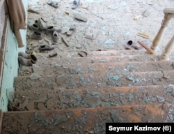 Cioburi de sticlă de la geamuri sparte pe o scară în Gazyan