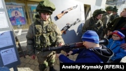 Copiii se joacă cu echipament militar la o sărbătoare a „Zilei Apărătorului Rus al Patriei” în Simferopol, Crimeea, în februarie 2020.