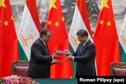 Presidenti kinez Xi Jinping (djathtas) me presidentin taxhik, Emomali Rahmon, duke shkëmbyer dokumente gjatë një ceremonie nënshkrimi në Pekin, më 31 gusht 2017.
