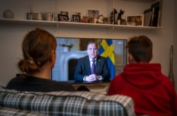 Qytetarët në Suedi duke ndjekur fjalimin drejtuar kombit të kryeministrit Lofven.