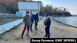 Участници в неделната акция на фона на двуетажната постройка на плажа, обявена за събаряне