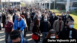 Građani čekaju u redu da prime dozu vakcine AstraZeneca u improvizovanom centru za vakcinaciju na Beogradskom sajmu u Beogradu, 27. marta 2021.