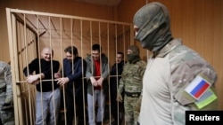 Captured Ukrainian sailors, await trial in Moscow last month.