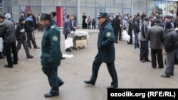 Сотрудники узбекской милиции идут по местному рынку. 