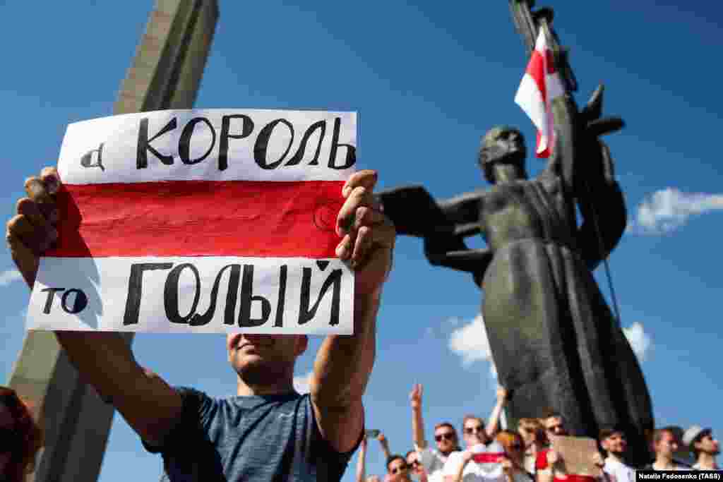 Демонстрант со транспарент: &bdquo;Кралот е гол&ldquo;, за време на митингот на опозицијата во Минск на 16 август.