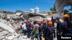 Egy mentőcsapat tagjai a 7,2 -es erősségű földrengés után Les Cayes -ben, Haiti, 2021. augusztus 15-én