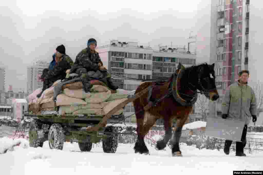 Din cauza lipsei de combustibili, militari ai armatei bosniace folosesc un cal și o căruță pentru a transporta alimente în cartierul Sarajevo Nou, din apropiere de aeroport, 5 ianuarie 1995. 
