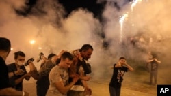 Un bărbat rănit este cărat de alte persoane în timpul protestului violent de duminică seară