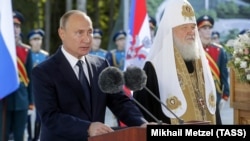 Vladimir Putin (stânga) și patriarhul Kirill la ceremonia de binecuvântare a pietrei de temelie a catedralei Forțelor Armate Ruse în parcul militar Patriot, Moscova, 19 septembrie 2018