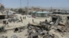 Afghan security personnel keep watch at the scene of the July 15 suicide attack in Orgun district, Paktika province, July 16, 2014.