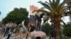Njerëzit qëndrojnë mbi një statujë të rrëzuar të presidentit të dikurshëm të Sirisë, Hafez al-Assad, në Damask më 8 dhjetor 2024.