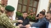 Прикордонник (ліворуч) подає протокол про адміністративне правопорушення колишньому грузинському президенту Міхеїлу Саакашвілі (в центрі) біля готелю у Львові, 12 вересня 2017 року