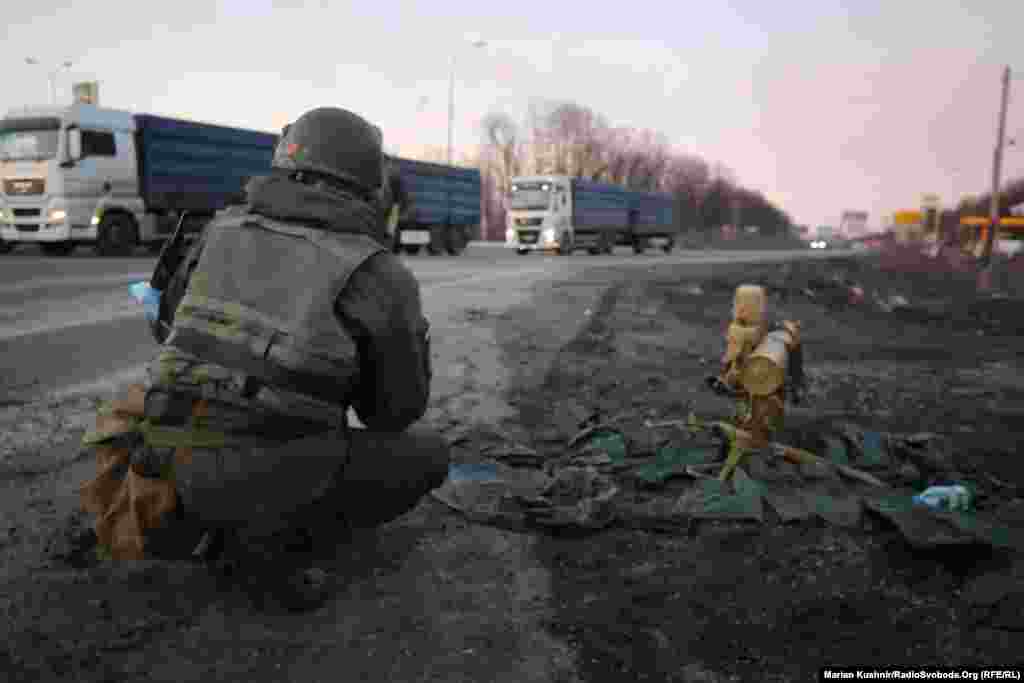 A Ukrainian soldier crouches next to an anti-tank missile at the scene of the battle on the outskirts of Kharkiv.&nbsp;