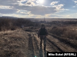 Украински войник върви към позицията си в село Зайцево