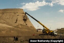 Рабочие ремонтируют недавно отреставрированные стены древней крепости в Хиве в 2019 году