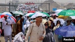 Pelegrinët myslimanë ecin me çadra për shkak të të nxehtit ekstrem gjatë haxhillëkut vjetor në Mina, Arabi Saudite, 18 qershor 2024.