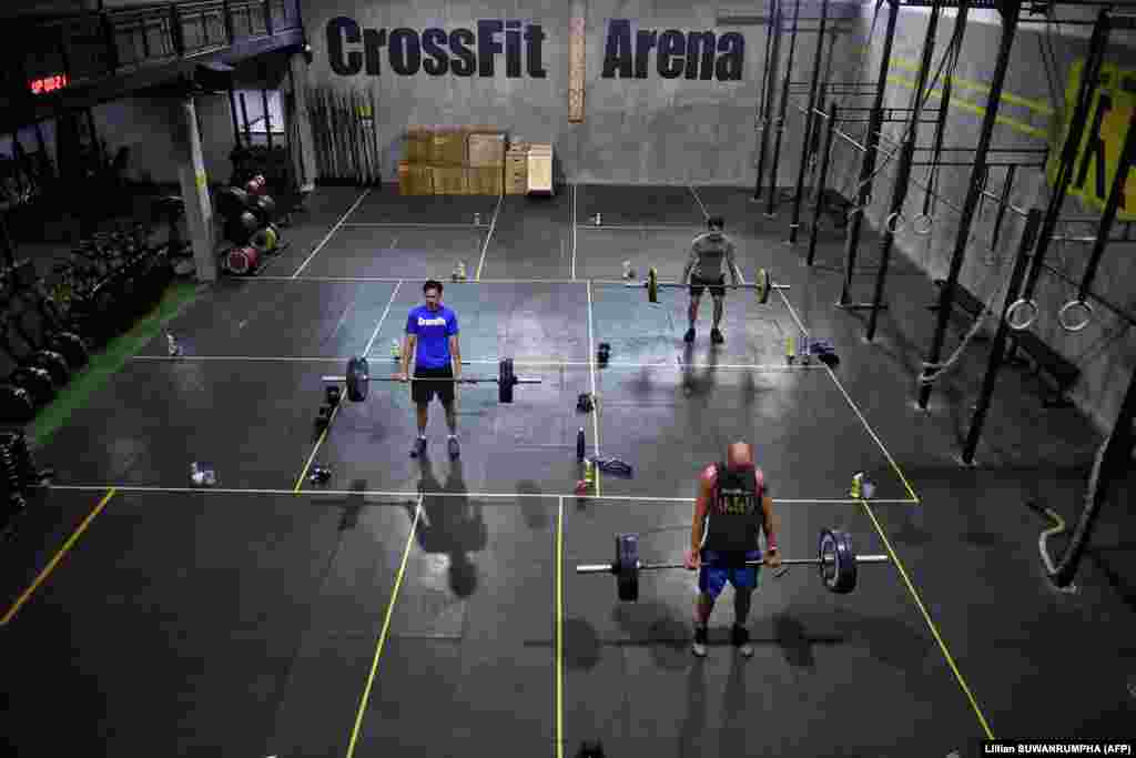 Ентузијасти во теретаните одржуваат растојание едни од други во CrossFit Arena Bangkok, за време на нивната прва недела од повторното отворање на овие центри.