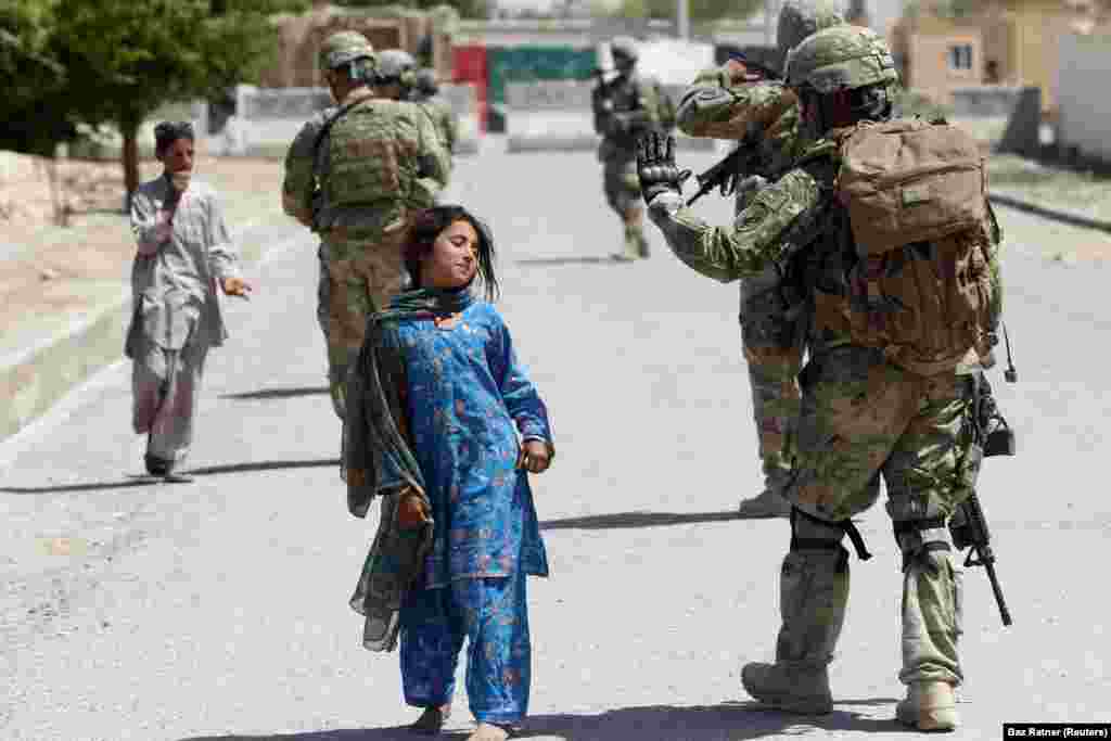 Devojčice prolazi pored američkog vojnika dok patrolira u provinciji Kandahar. (Hutal, 5. april 2012) 