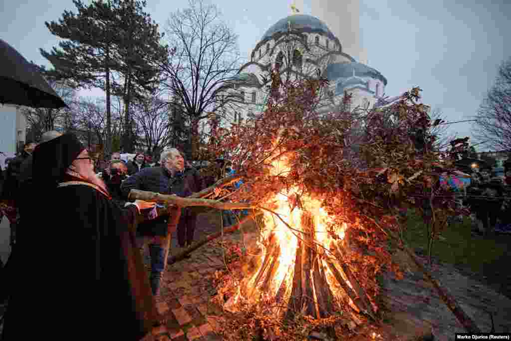 Credincioși arzând crengi de stejar în fața Catedralei Sf. Sava din Belgrad pe 6 ianuarie. Se crede că tradiția arderii stejarului este anterioară creștinismului, dar este acum o parte centrală a sărbătorilor de Crăciun în cea mai mare parte a Balcanilor.