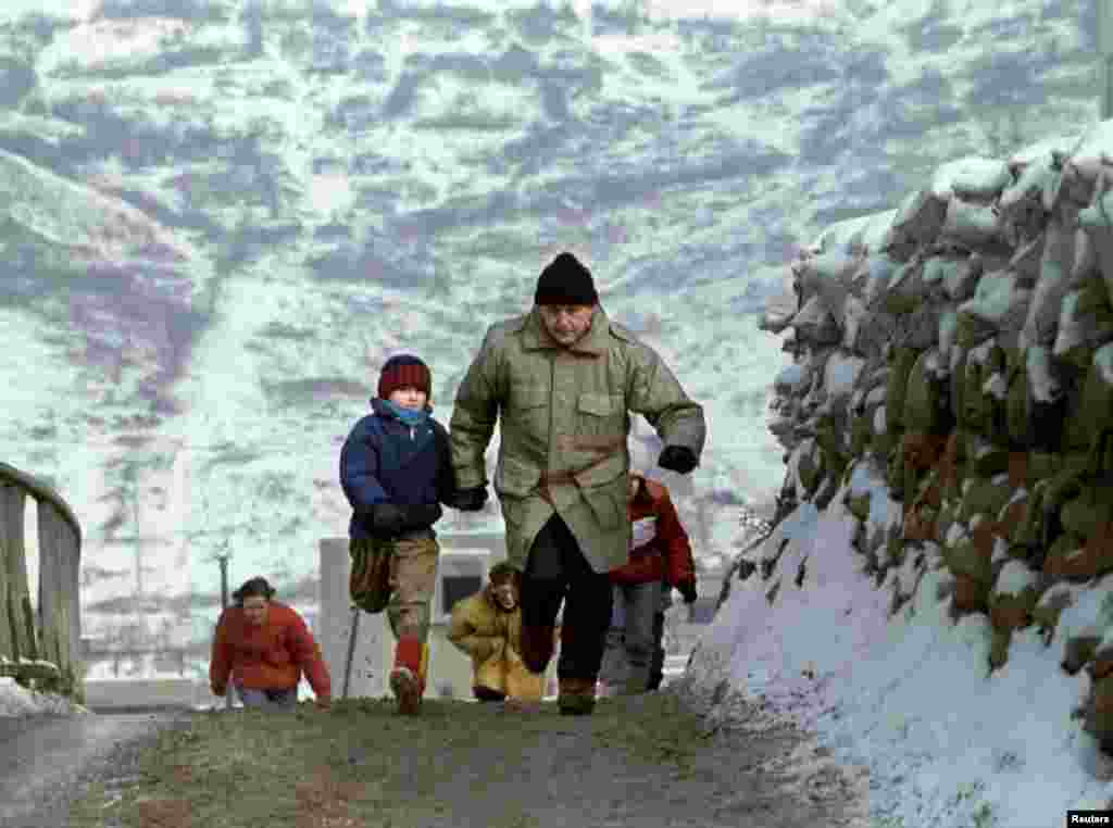 Un tată și fiul său fug în cartierul olimpic Dobrinjia, în încercarea de a se adopsti de tirurile lunetiștilor, 4 ianuarie 1993. 