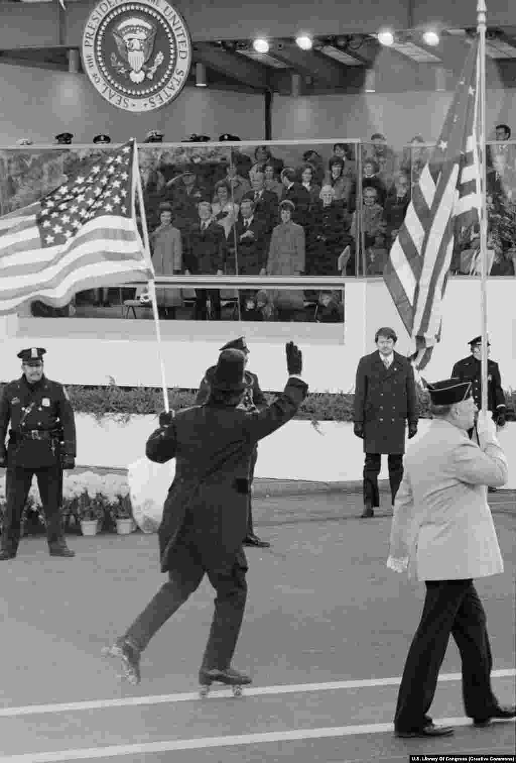 Një pjesëtar i patinazhit në paradën e inaugurimit përshëndet me dorë presidentin Jimmy Carter pas ceremonisë së betimit të tij më 20 janar 1977.