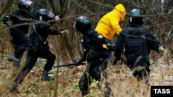 Membri ai forțelor de securitate din Belarus urmăresc undemonstrant la Minsk, noiembrie 2020