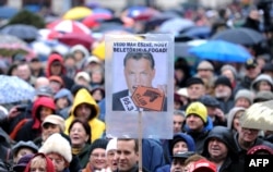 Zaposleni u mađarskoj radio stanici Klubradio i njihove pristalice s plakatom s fotografijom mađarskog premijera Viktora Orbana na kome piše: "Zar ne vidiš da je previše?" na protestu za slobodu govora u Budimpešti 24. februara 2013.