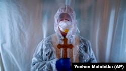 Sztefán atya, az ukrán görögkatolikus egyház papja védőöltözetben a nyugat-ukrajnai Lviv városának egy kórházában, miután meglátogatta a intenzív ápolásra szoruló koronavírusos betegeket 2020. január 9-én.
