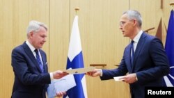 Ministri i Jashtëm finlandez, Pekka Haavisto, teksa ia dorëzon dokumentin e anëtarësimit Sekretarit të Përgjithshëm të NATO-s, Jens Stoltenberg. Bruksel, Belgjikë, 4 prill 2023.