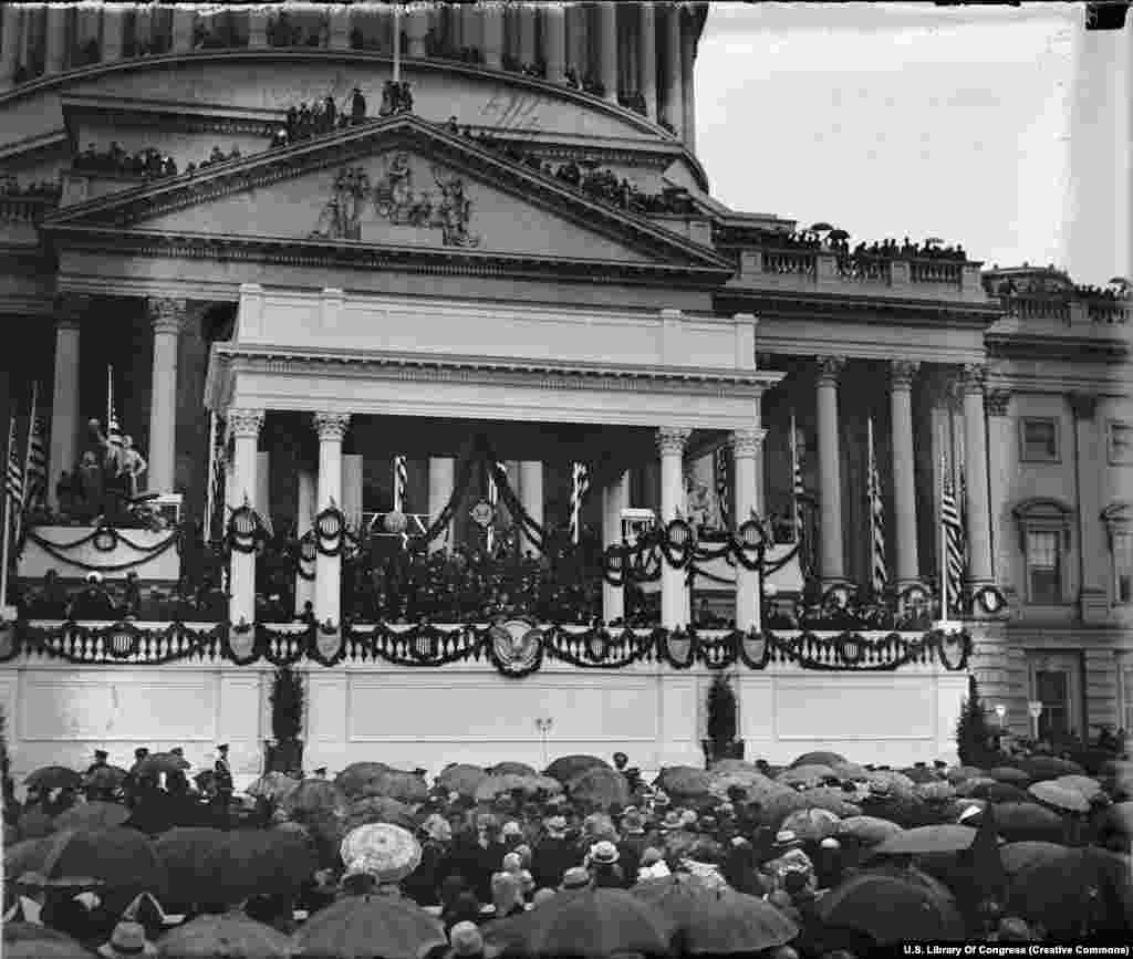  Mulțimea se adună pe peluza și chiar pe acoperișul Capitoliului Statelor Unite pentru a asculta discursul de inaugurare sau învestire al președintelui Herbert Hoover, la 4 martie 1929. Data inaugurărilor a fost stabilită inițial pentru 4 martie, dar, în încercarea de a reduce perioada de &bdquo;interimat&rdquo; dintre administrații, un amendament constituțional din 1933 a decretat că viitoarele învestiri vor avea loc pe 20 ianuarie.&lt;
