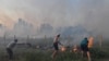 Banorët përpiqen të shuajnë një zjarr në qytetin bregdetar veriperëndimor të Algjerisë, Tabarka, më 24 korrik 2023.