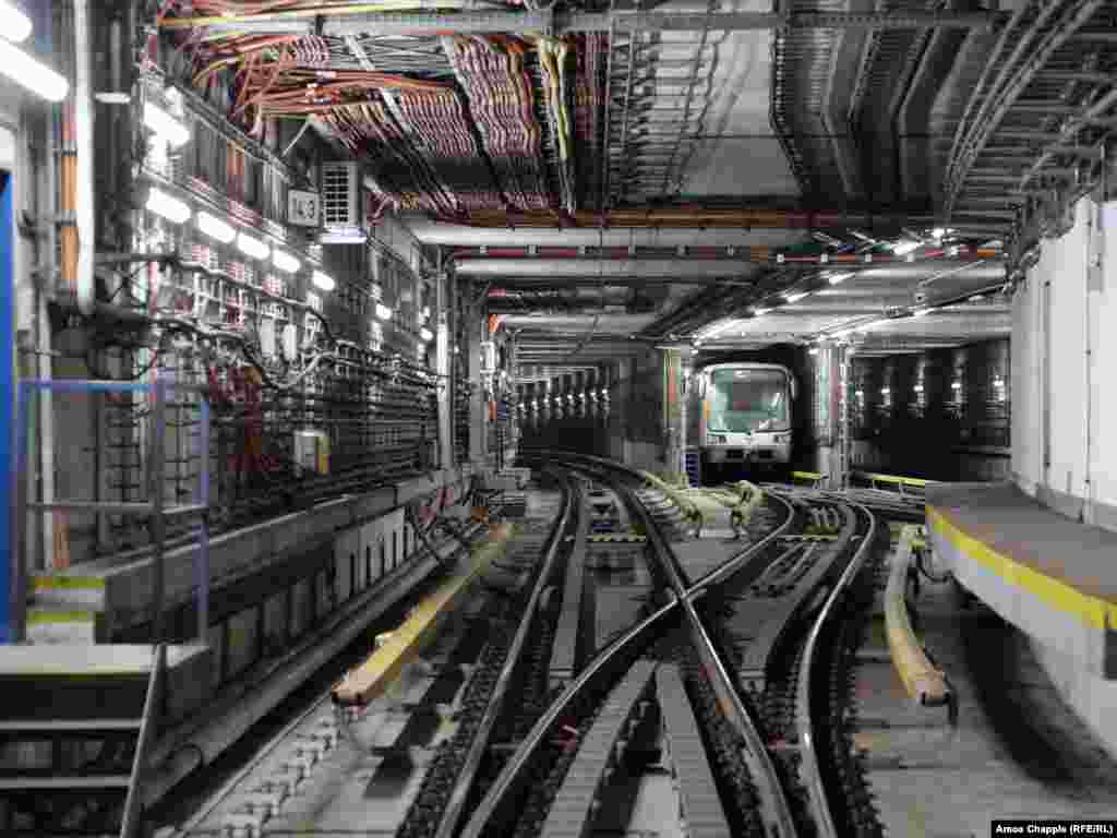 Një tren metroje pret detyrat e tij në mëngjes, ndërsa një derë rezistente kundër shpërthimeve testohet aty pranë. Sot, autoritetet e Pragës e përshkruajnë qëllimin e Sistemit Mbrojtës të Metrosë së qytetit që &quot;të mbrojë popullsinë nga ndikimi i armëve të shkatërrimit në masë për një periudhë prej 72 orësh&quot; dhe &quot;të izolojë pjesë të metrosë në rast të një përmbytjeje të madhe&quot;.