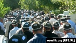 Мужчины в национальной тюбетейке, участвующие в похоронной процессии. 