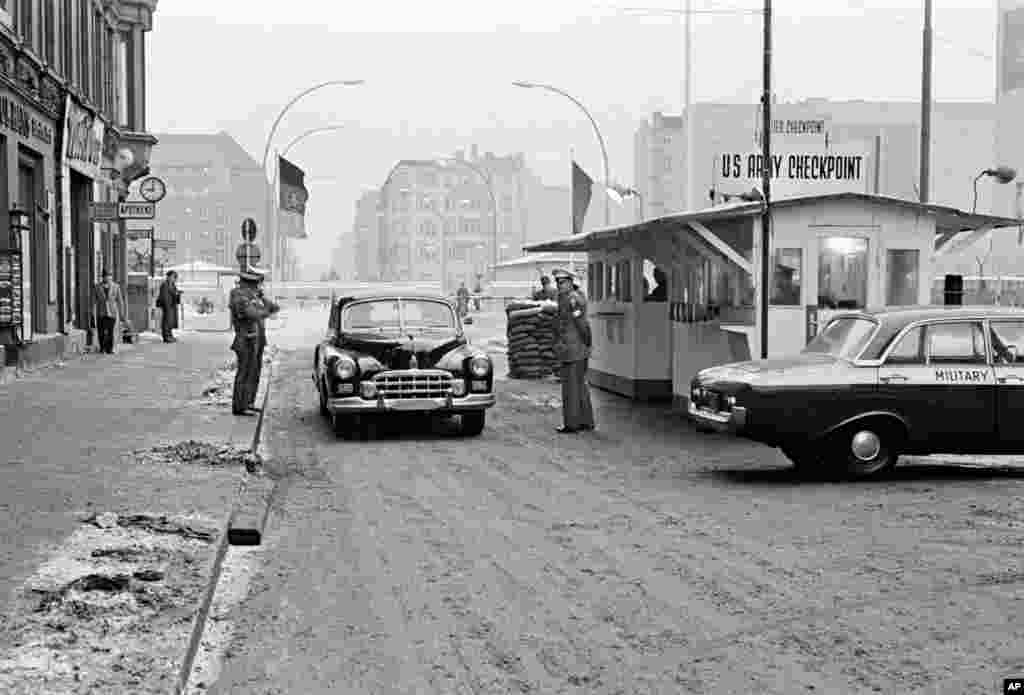 Një makinë duke kaluar nga Berlini lindor në perëndim të tij në pikën e kontrollit Charlie në tetorin e vitit 1964. Ky vendkalim ishte e vetmja pikë përmes së cilës të huajve u lejohej të kalonin. &nbsp;