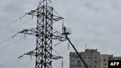 Një punëtor duke e ndrequr një linjë të rrymës, pas një sulmi raketor në Harkiv, 6 prill 2024.