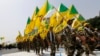 Irakianët myslimanë shiit të grupit të mbështetur nga Irani, Kataib Hezbollah, duke mbajtur në dorë flamuj teksa ecin në një rrugë të ngjyrosur me ngjyrat e flamurit izraelit gjatë një parade për shënimin e Ditës së Jerusalemit në Bagdad, Irak, 25 korrik 2014.