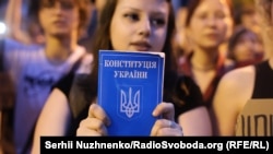 Жена държи в ръце Конституцията на Украйна по време на протест в Киев, 22 юли 2025 г.