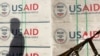 Silueta e një personi pranë pakove me ndihma nga USAID. Fotografi nga arkivi.